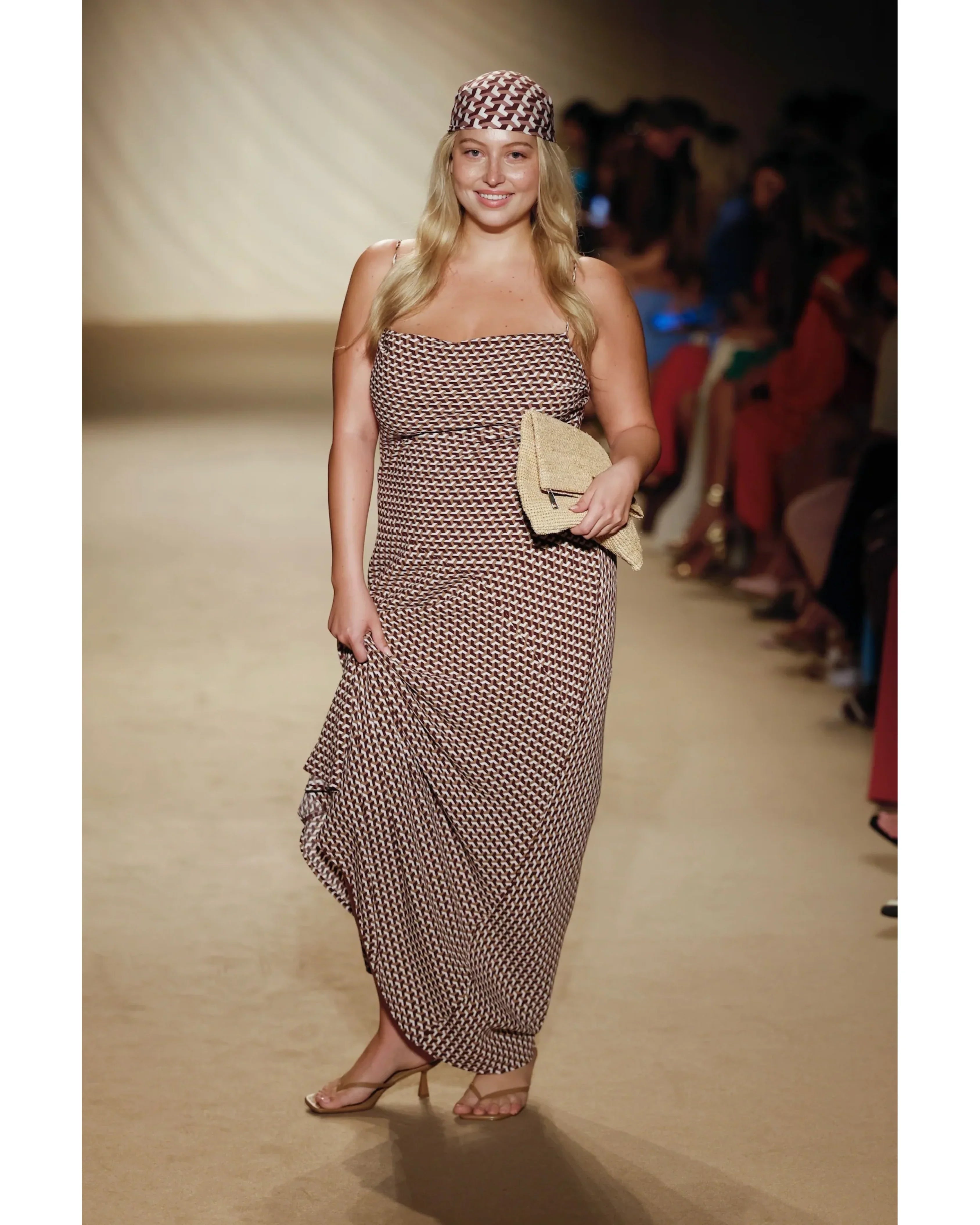 Model wearing brown geometric print strapless maxi dress with matching headscarf and woven clutch on runway — Monday Swimwear | Endless UAE