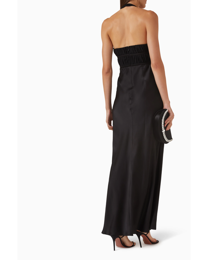 Woman wearing black halter maxi dress with ruched waist detail and silver accent — Misha | Endless UAE
