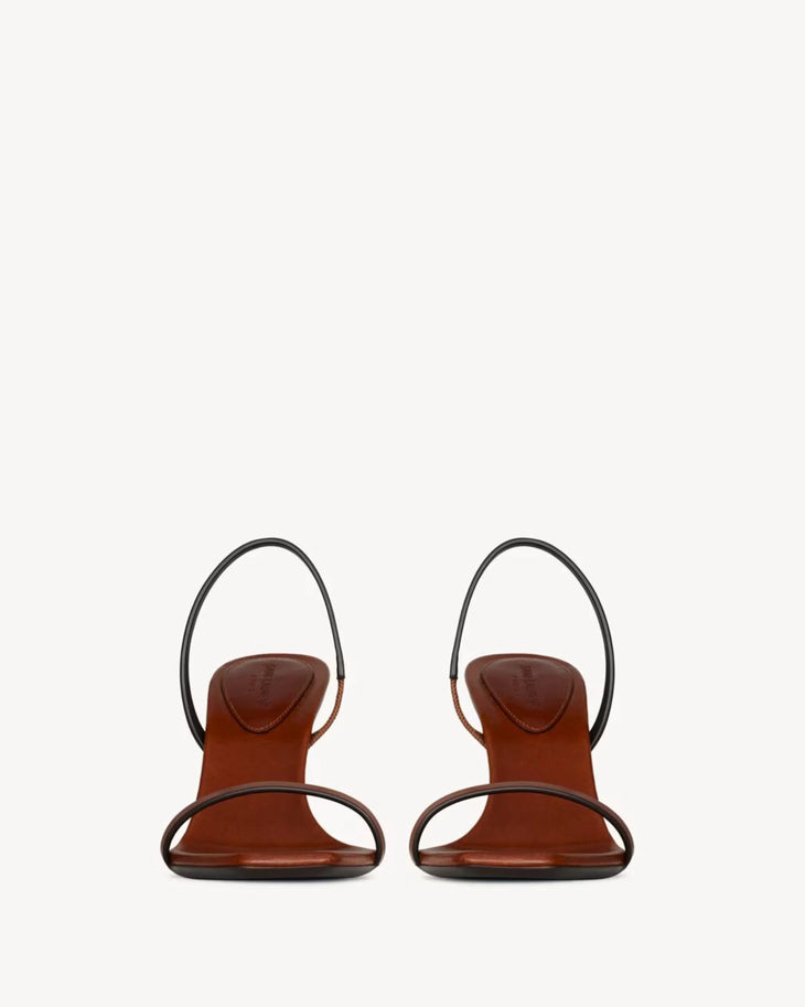 Brown leather slingback sandals with thin asymmetric straps and low heel viewed from front — Saint Laurent | Endless UAE