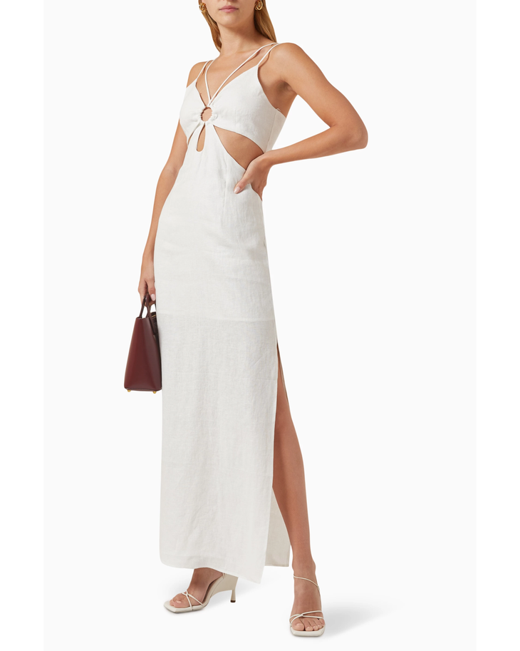 White linen maxi dress with cutout detail, ring accent, and high slit worn with strappy heels and brown handbag — Misha | Endless UAE
