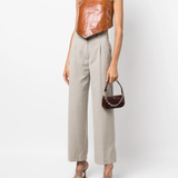 Dark brown croc-embossed mini shoulder bag with chain detail held in hand — By Far | Endless UAE