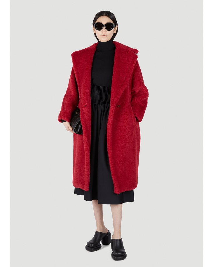 Woman wearing vibrant red teddy bear coat over black turtleneck and midi skirt with sunglasses — Max Mara | Endless UAE