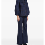 Woman wearing indigo denim jacket and flared jeans with white clutch — Florence & Fortitude | Endless UAE