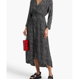 Woman wearing a black and white printed wrap midi dress with long sleeves, styled with black sandals and a red handbag — Maje | Endless UAE