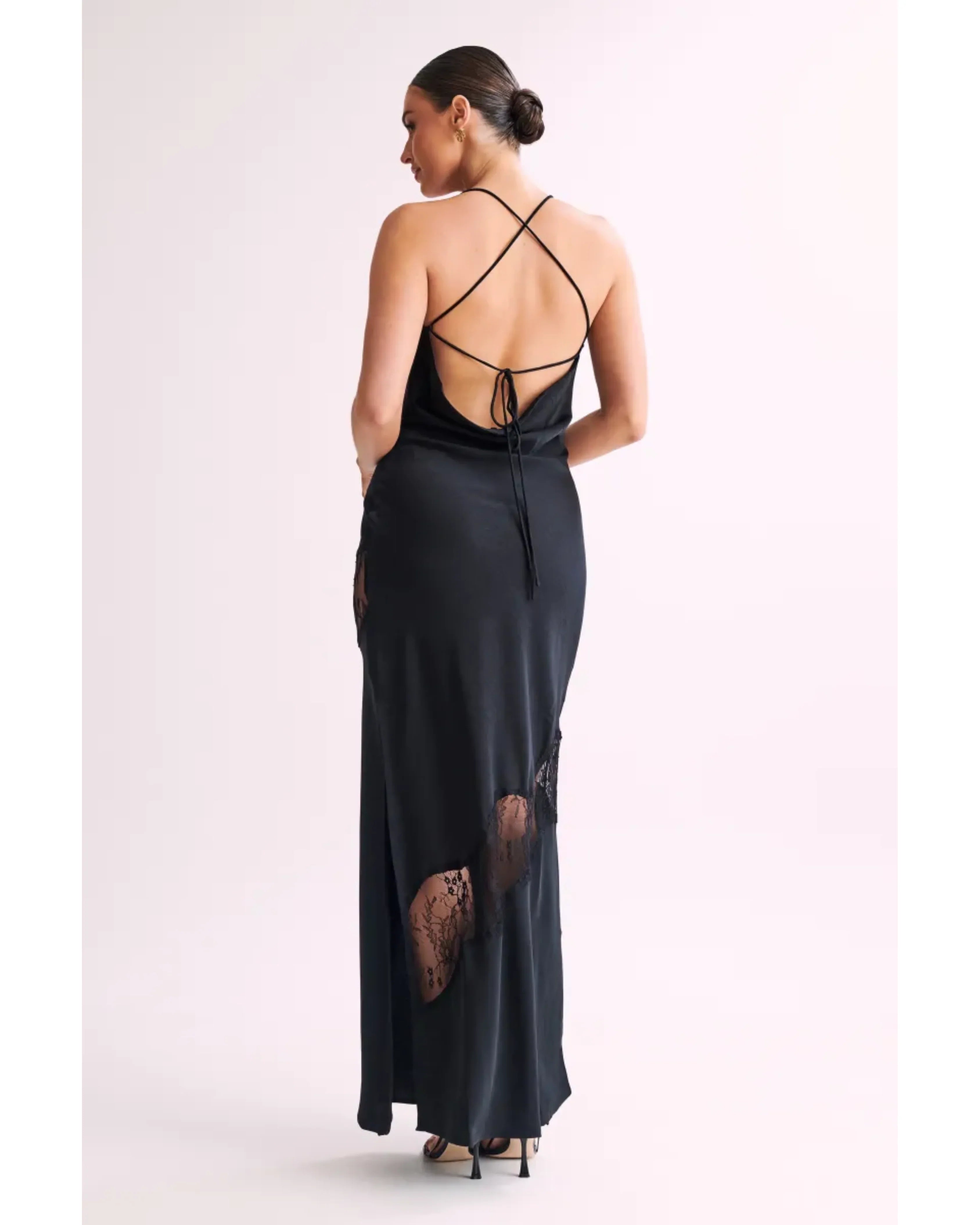 Woman wearing black satin maxi dress with lace side detail and halter neckline — Meshki | Endless UAE