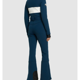 Woman wearing navy and white colorblocked ski jumpsuit with belt and black boots — Cordova | Endless UAE