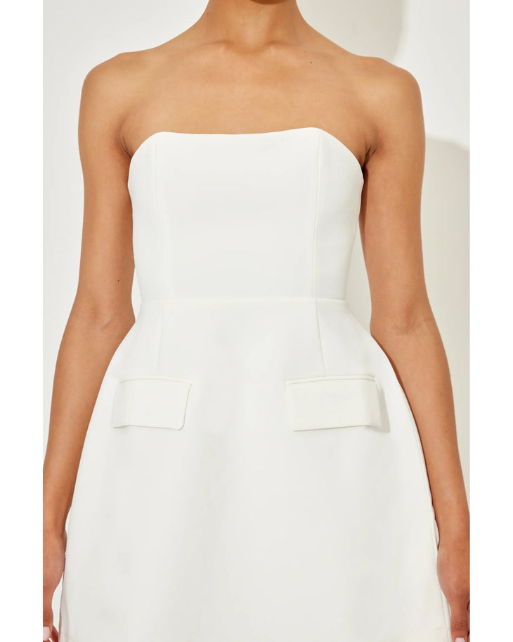 Woman wearing a white strapless dress with pockets and a flared skirt — Odd Muse | Endless UAE