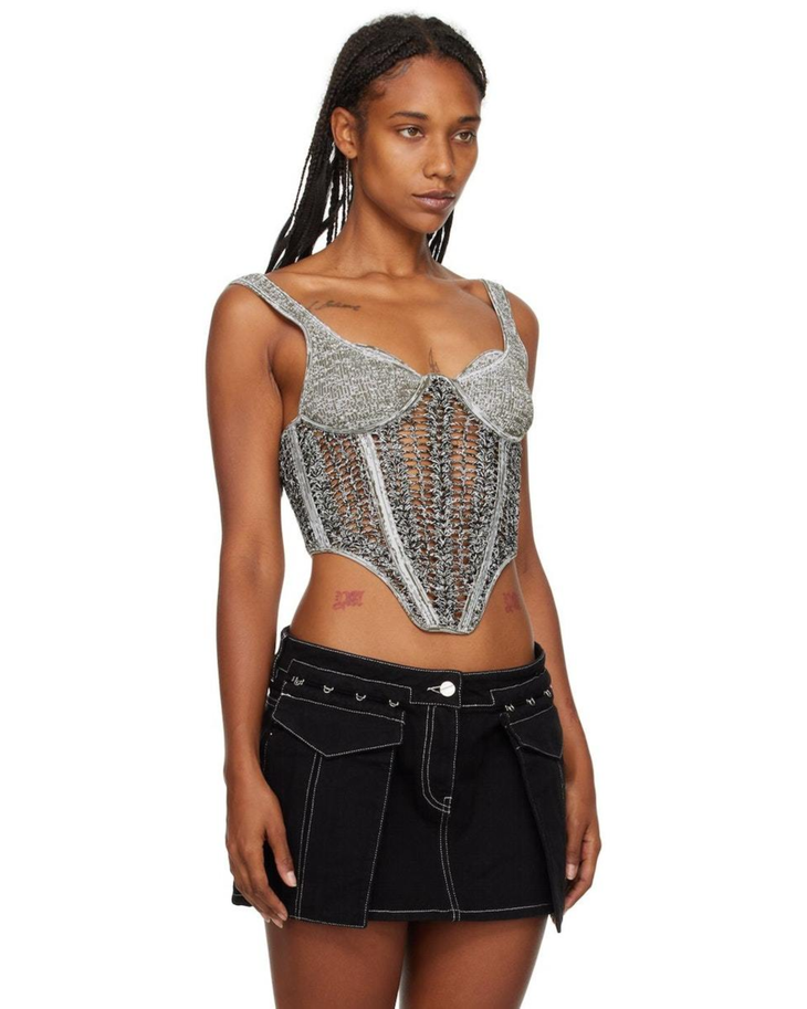 Metallic silver crochet corset top with mesh panels and underwire bust detail, paired with black mini skirt — Dion Lee | Endless UAE