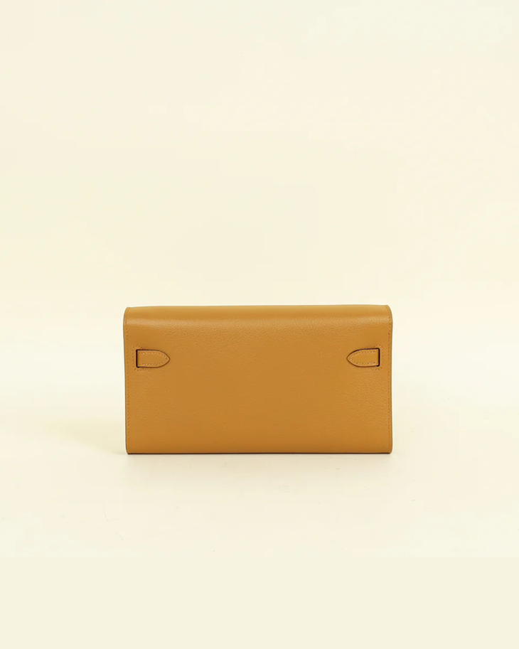 Tan leather Hermes Sesame Kelly To Go Evercolor Wallet with stitched tab details on front flap against cream background — Hermes | Endless UAE