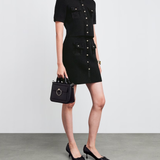 Black knitted mini skirt with button-down front and patch pockets styled with matching cardigan and heels — Claudie Pierlot | Endless UAE