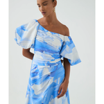 Woman wearing blue and white abstract print Cadence Ruched Midi Dress with puffed sleeves and white slides — Aje | Endless UAE