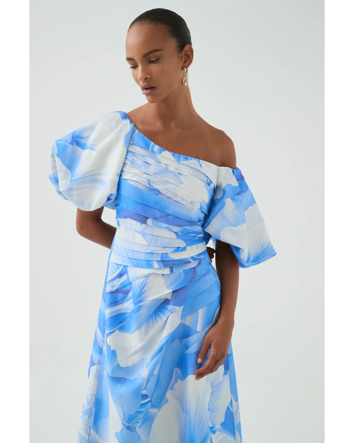 Woman wearing blue and white abstract print Cadence Ruched Midi Dress with puffed sleeves and white slides — Aje | Endless UAE