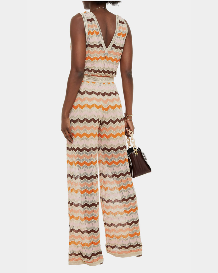 Woman wearing a colorful striped cotton jumpsuit with orange, brown and cream zigzag pattern — Missoni | Endless UAE