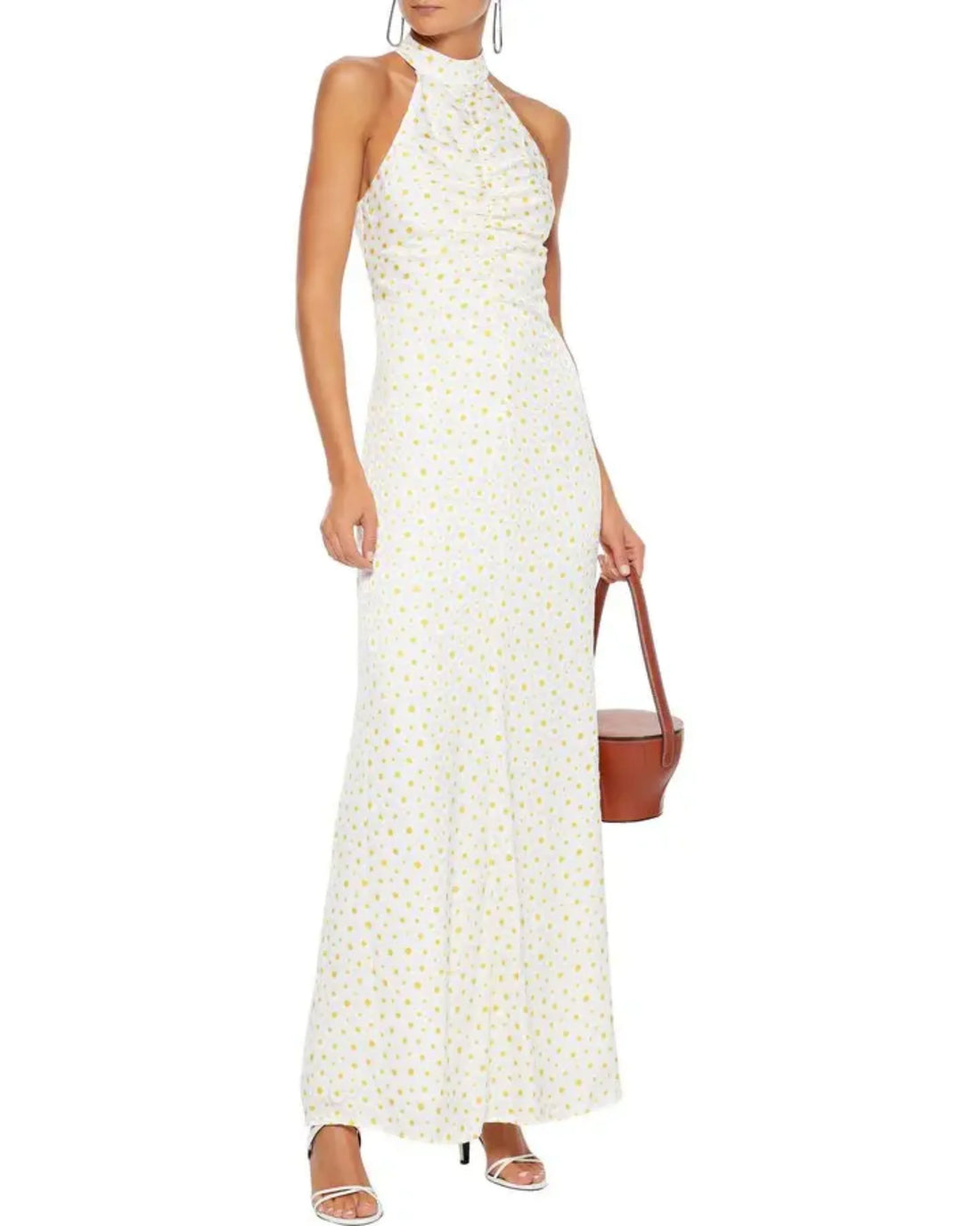 Woman wearing white Coastal Daisy Maxi Dress with yellow floral print and halter neckline — Staud | Endless UAE