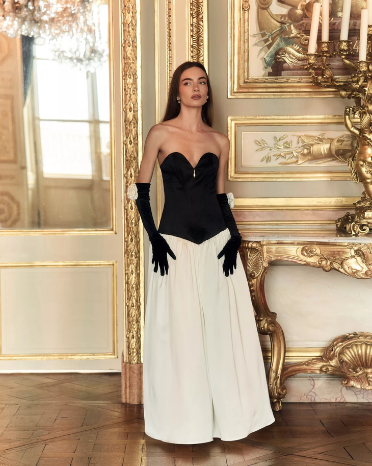 Woman wearing black and white off-shoulder Parisienne Maxi Dress in ornate palace room — Lichi | Endless UAE