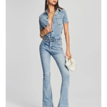 Woman wearing light blue denim Fallon Jumpsuit with short sleeves and flared legs — SER.O.YA | Endless UAE