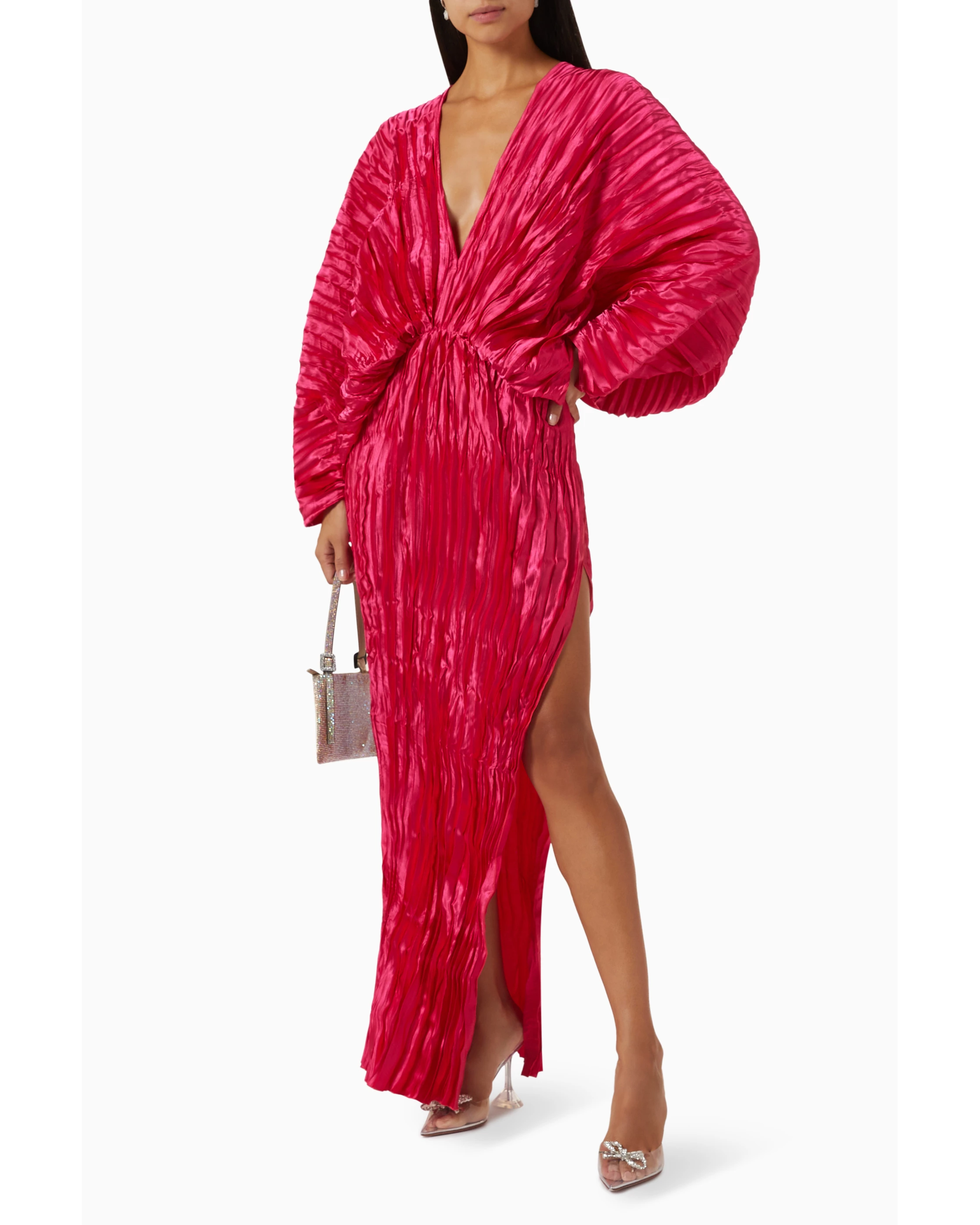 Woman wearing a fuchsia crinkled pleated oversized maxi dress with wrap front and voluminous sleeves — L'IDÉE | Endless UAE