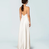 Elegant ivory sleeveless gown with deep V-back, flowing A-line silhouette, and floor-length hem — Fame & Partners | Endless UAE