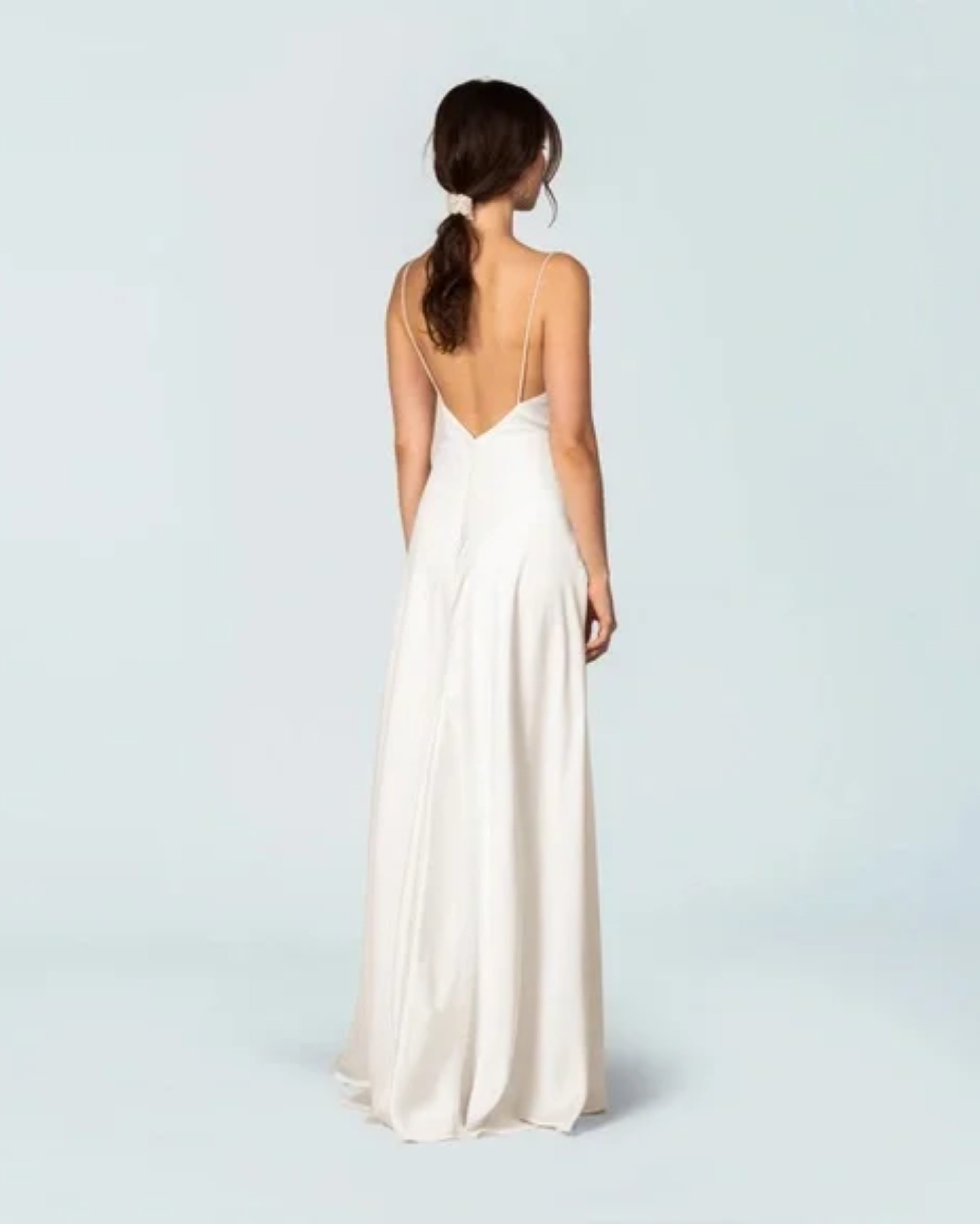 Elegant ivory sleeveless gown with deep V-back, flowing A-line silhouette, and floor-length hem — Fame & Partners | Endless UAE