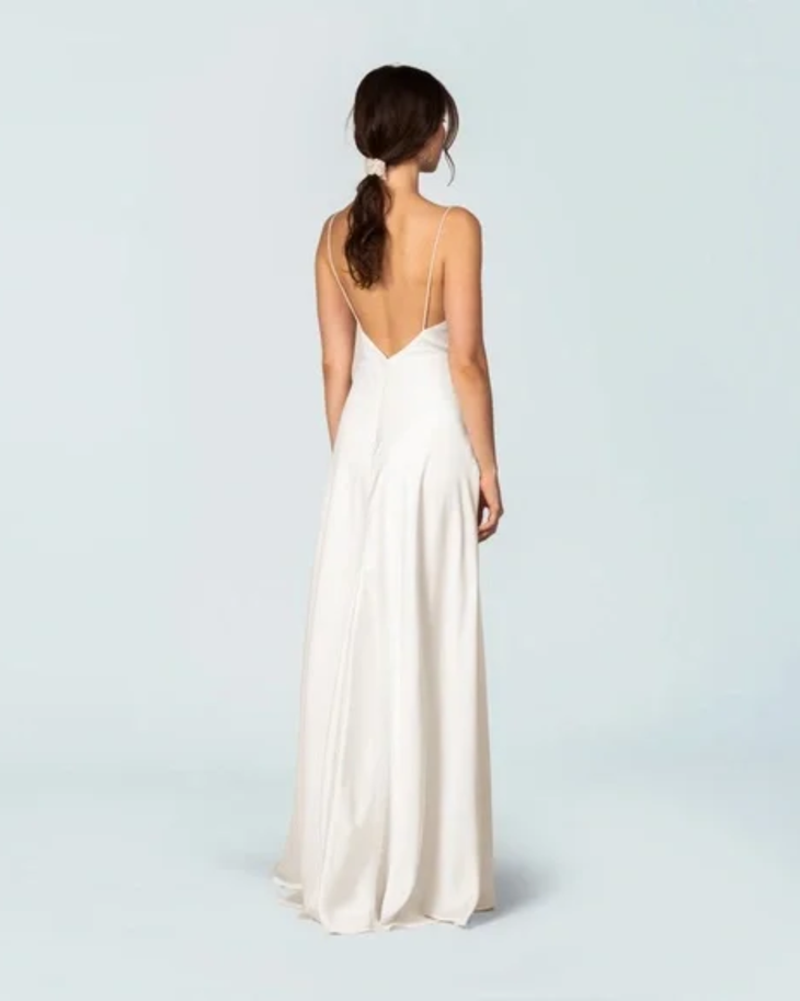 Elegant ivory sleeveless gown with deep V-back, flowing A-line silhouette, and floor-length hem — Fame & Partners | Endless UAE