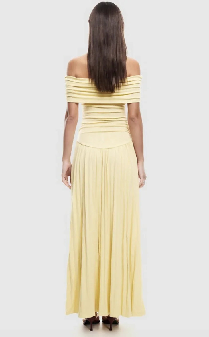 Woman wearing pale yellow off-shoulder maxi dress with ruched bodice and pleated skirt — Lioness | Endless UAE