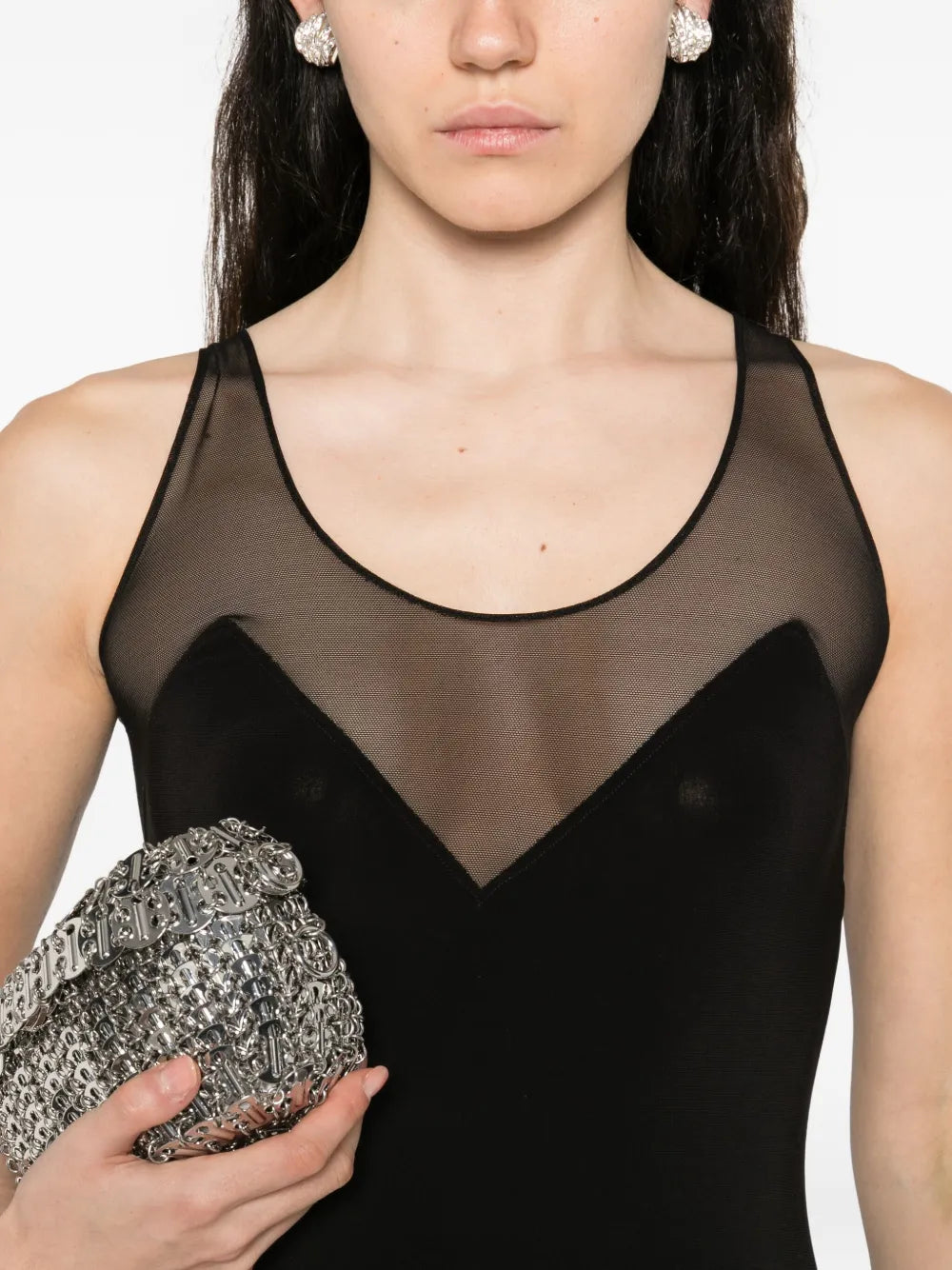 Black maxi dress with sheer mesh panel detail at neckline and racerback design, styled with silver clutch and crystal earrings — Norma Kamali | Endless UAE