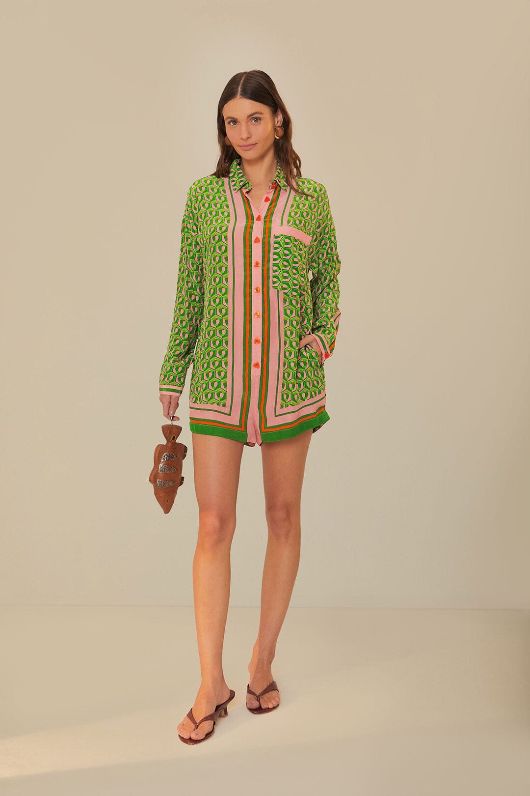 Woman wearing green patterned button-up romper with striped trim and brown accessories — Farm Rio | Endless UAE