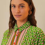 Woman wearing green patterned button-up romper with striped trim and brown accessories — Farm Rio | Endless UAE