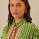 Woman wearing green patterned button-up romper with striped trim and brown accessories — Farm Rio | Endless UAE