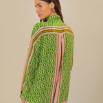 Woman wearing green patterned button-up romper with striped trim and brown accessories — Farm Rio | Endless UAE