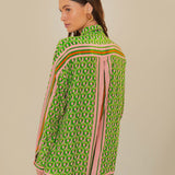 Woman wearing green patterned button-up romper with striped trim and brown accessories — Farm Rio | Endless UAE