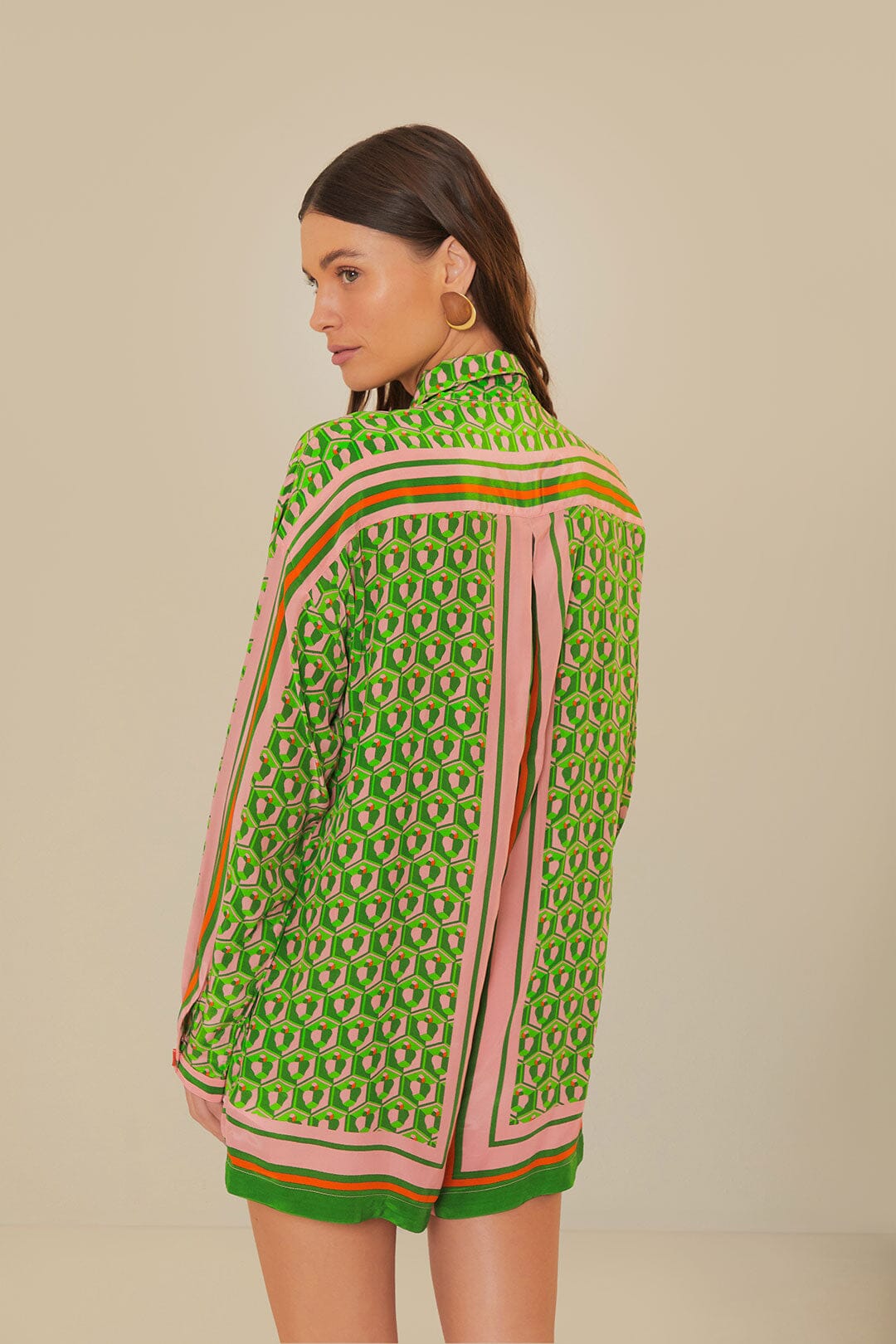 Woman wearing green patterned button-up romper with striped trim and brown accessories — Farm Rio | Endless UAE