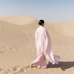 Woman wearing pink textured maxi dress in desert setting — Lichi | Endless UAE