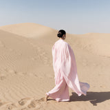 Woman wearing pink textured maxi dress in desert setting — Lichi | Endless UAE