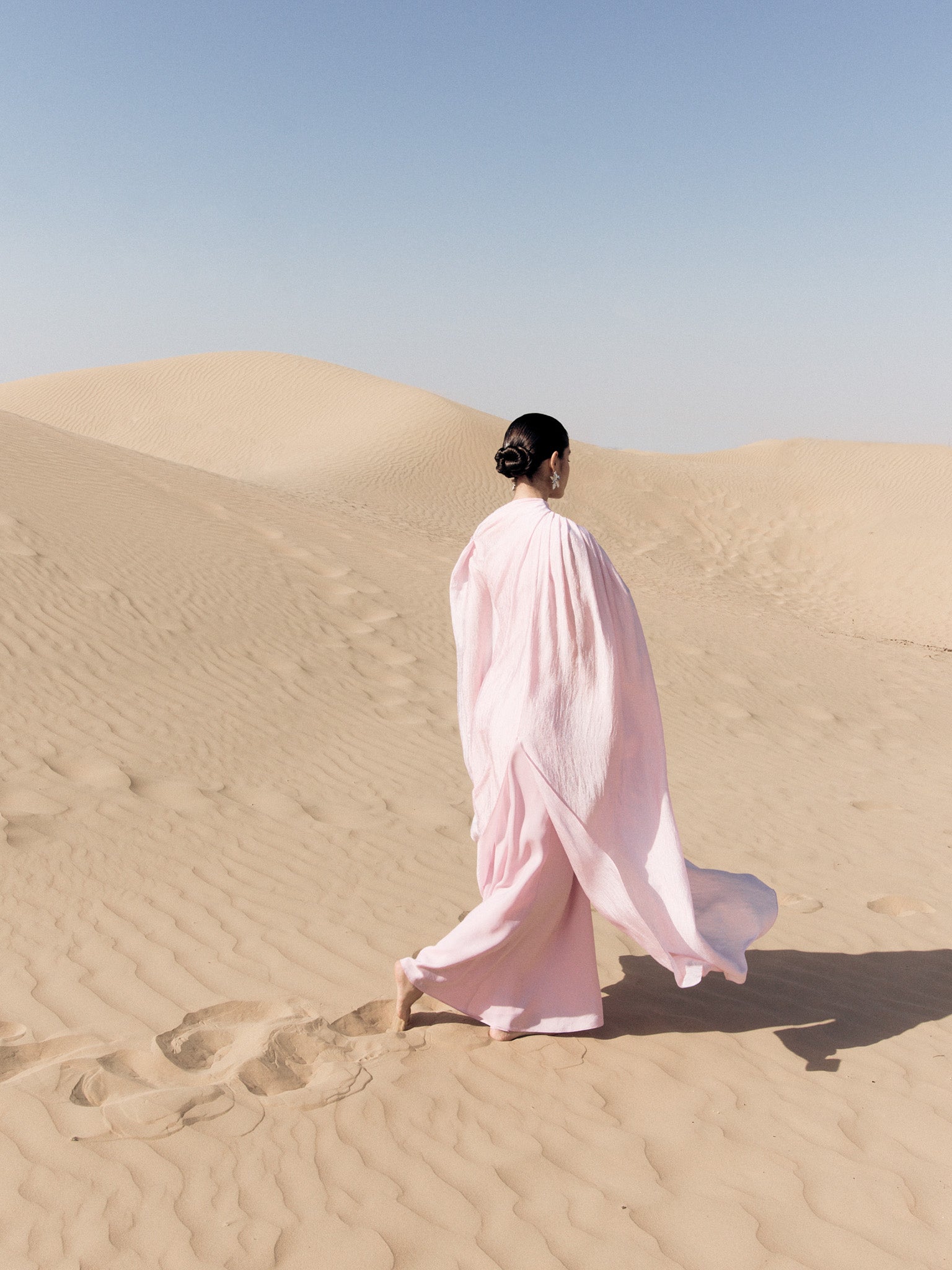 Woman wearing pink textured maxi dress in desert setting — Lichi | Endless UAE