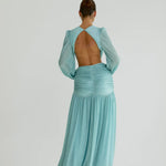 Woman wearing a flowing light blue wrap dress with long sleeves and cutout waist detail — Anne Louise Boutique | Endless UAE