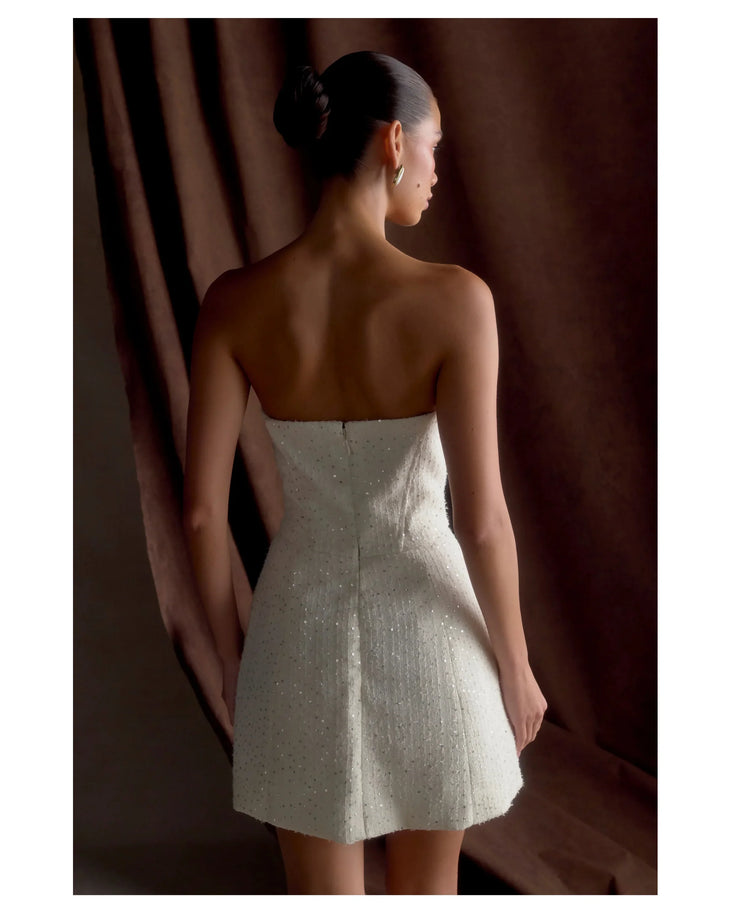 Woman wearing white strapless tweed corset mini dress against black background — Meshki | Endless UAE