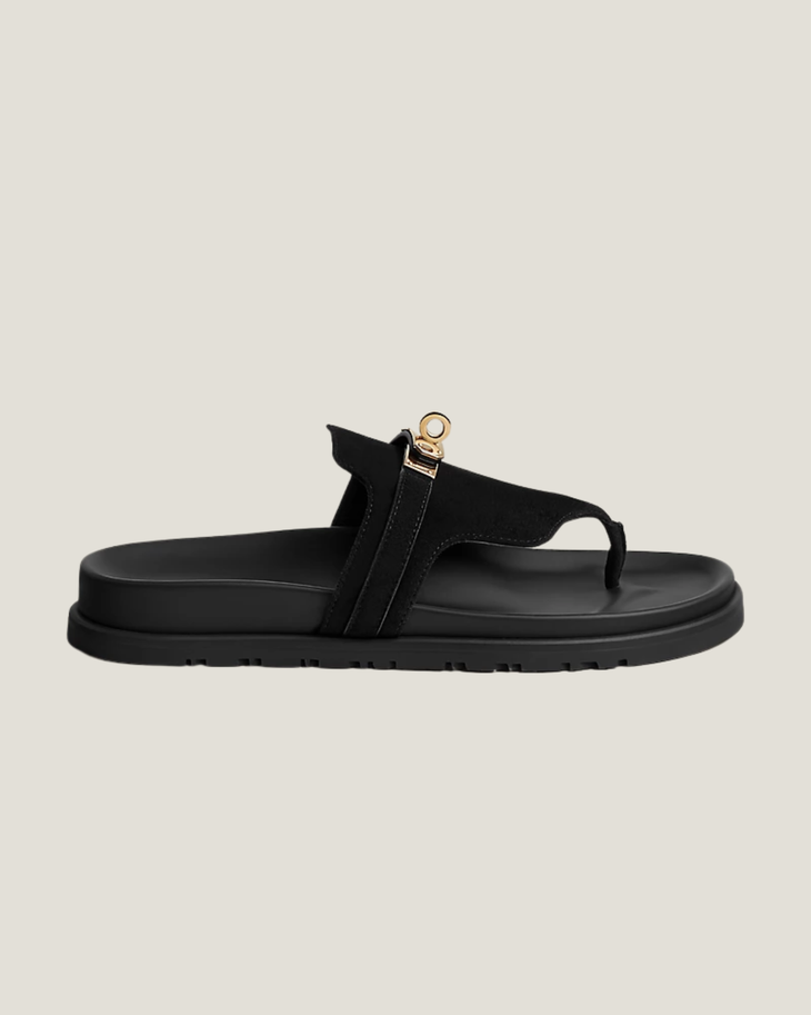 Black leather thong sandal with gold-tone stirrup hardware detail and chunky rubber sole — Hermes | Endless UAE
