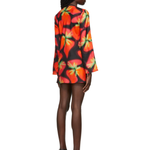Woman wearing vibrant red and orange strawberry print blazer dress with green handbag — Louisa Ballou | Endless UAE