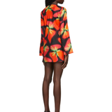 Woman wearing vibrant red and orange strawberry print blazer dress with green handbag — Louisa Ballou | Endless UAE