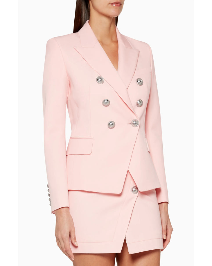 Woman wearing pink double-breasted Balmain blazer with matching skirt and black heels — Balmain | Endless UAE