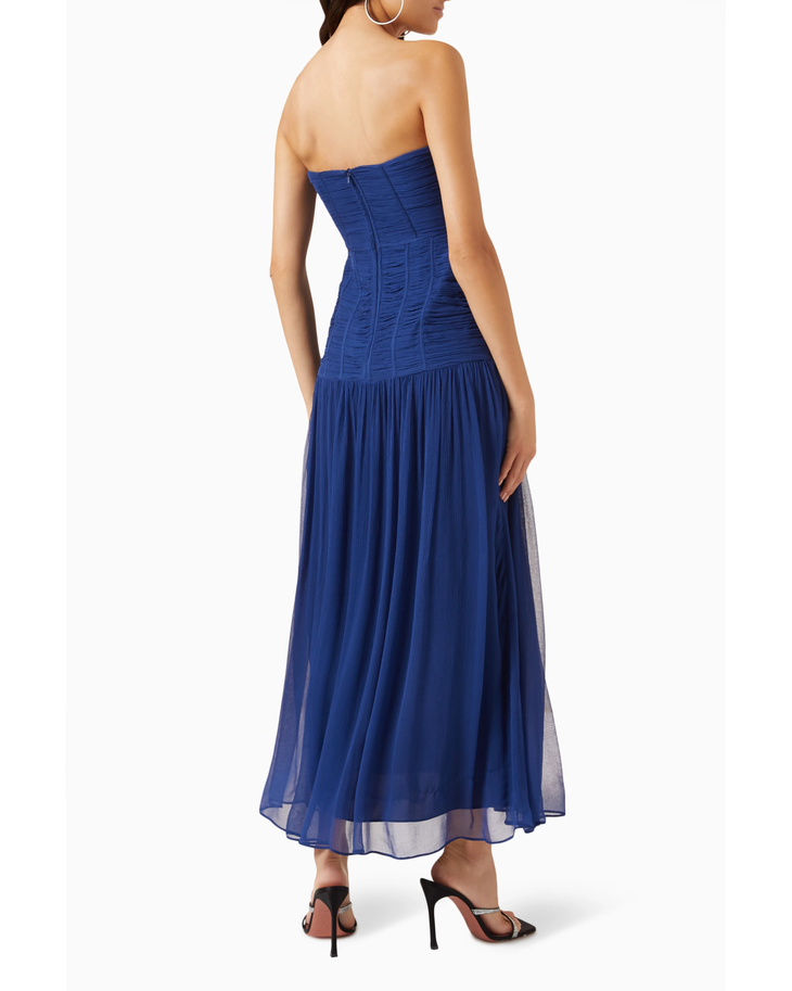 Woman wearing Isola Strapless Ruched Midi Dress in blue with black sandals — Shona Joy | Endless UAE