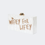Wifey For Lifey clear clutch bag with gold glitter text and gold-tone hardware — Sophia Webster | Endless UAE