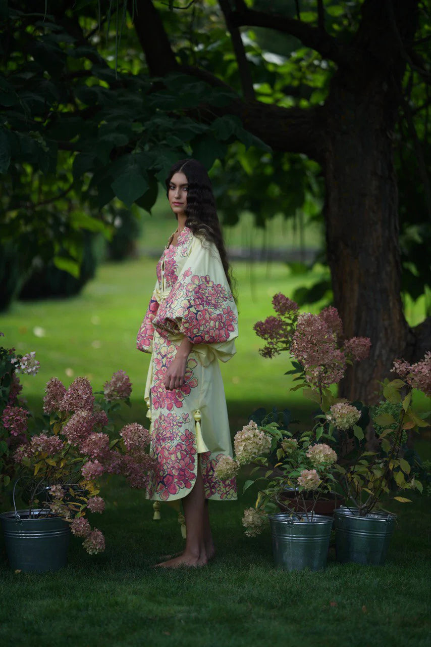 Woman wearing floral embroidered cotton caftan midi dress in garden setting with hydrangeas — Yuliya Magdych | Endless UAE
