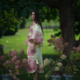 Woman wearing floral embroidered cotton caftan midi dress in garden setting with hydrangeas — Yuliya Magdych | Endless UAE