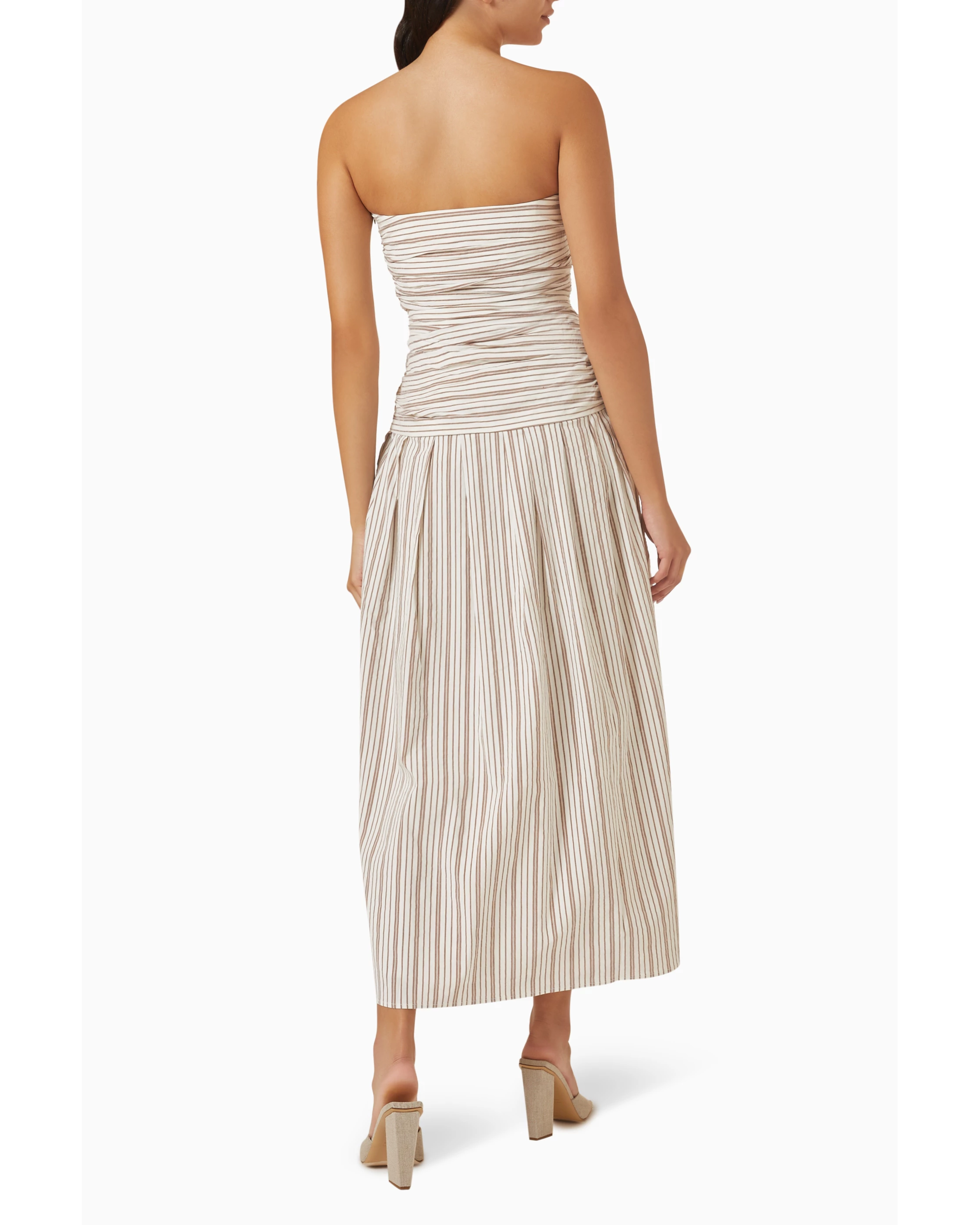 Woman wearing beige and white striped strapless midi dress with pleated skirt — Anna Quan | Endless UAE