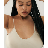 Woman wearing cream spaghetti strap slip dress with black strappy heels — Silk Laundry | Endless UAE