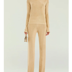 Woman wearing a beige metallic knit top and matching trousers holding a small handbag — SER.O.YA | Endless UAE