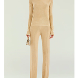 Woman wearing a beige metallic knit top and matching trousers holding a small handbag — SER.O.YA | Endless UAE