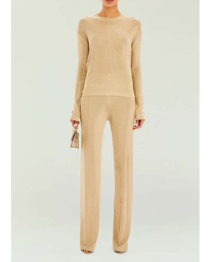 Woman wearing a beige metallic knit top and matching trousers holding a small handbag — SER.O.YA | Endless UAE